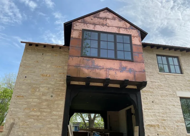 Copper metal panel facade on a stone building for Roof Repair in Chesterton
